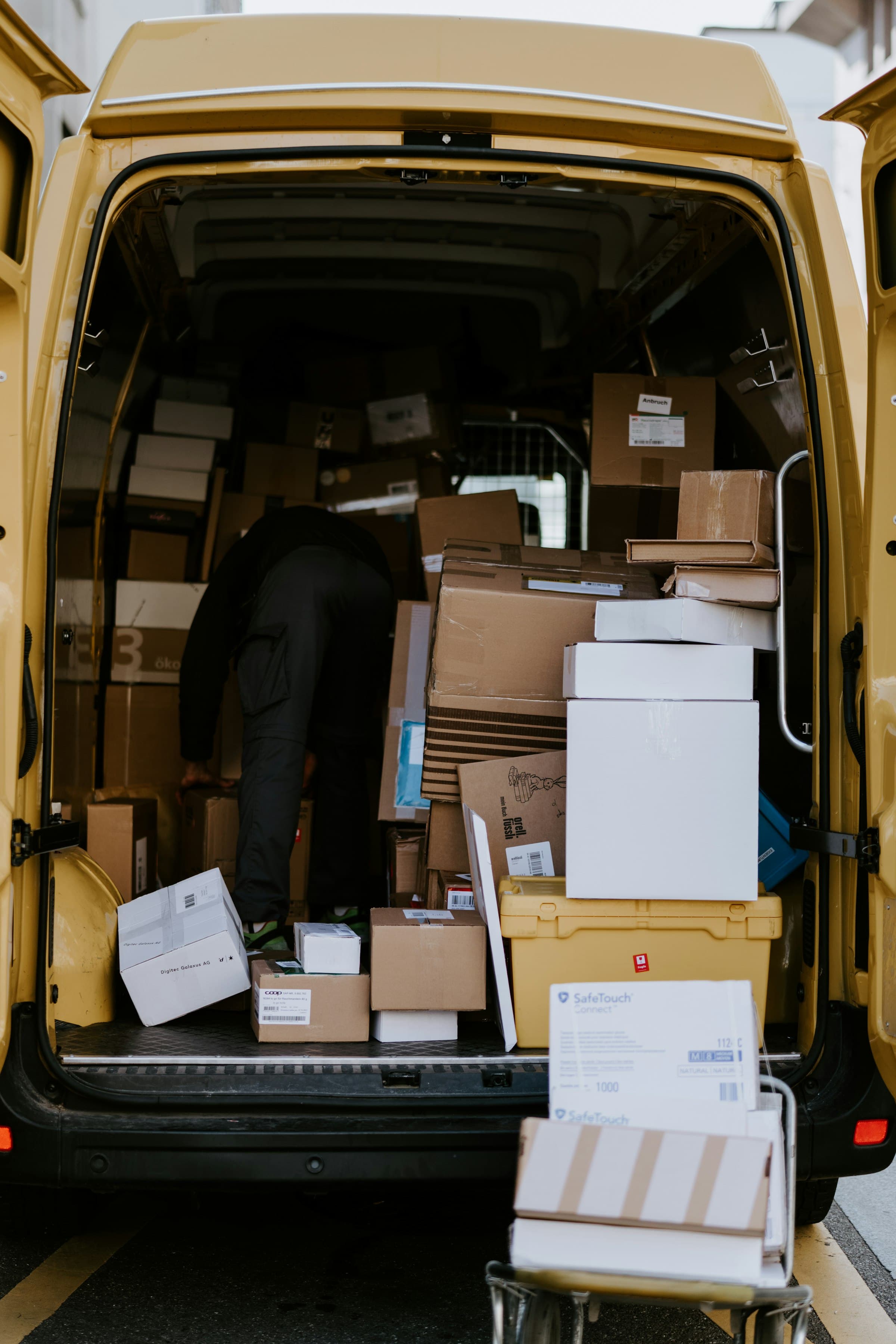 Un livreur charge des cartons à l'arrière d'un fourgon de livraison